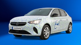 Opel Corsa-e mit Emil eCarSharing-Branding und grün-blauem Muster.