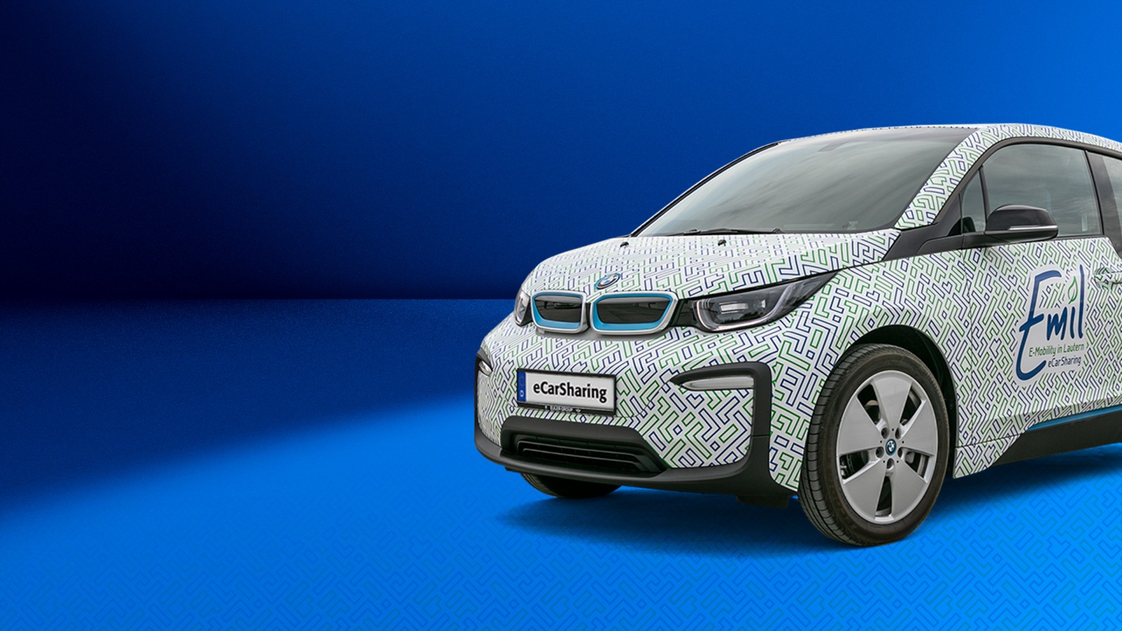 BMW i3 mit Emil eCarSharing-Branding auf blauem Hintergrund ragt rechts bis zu Hälfte ins Bild hinein. 